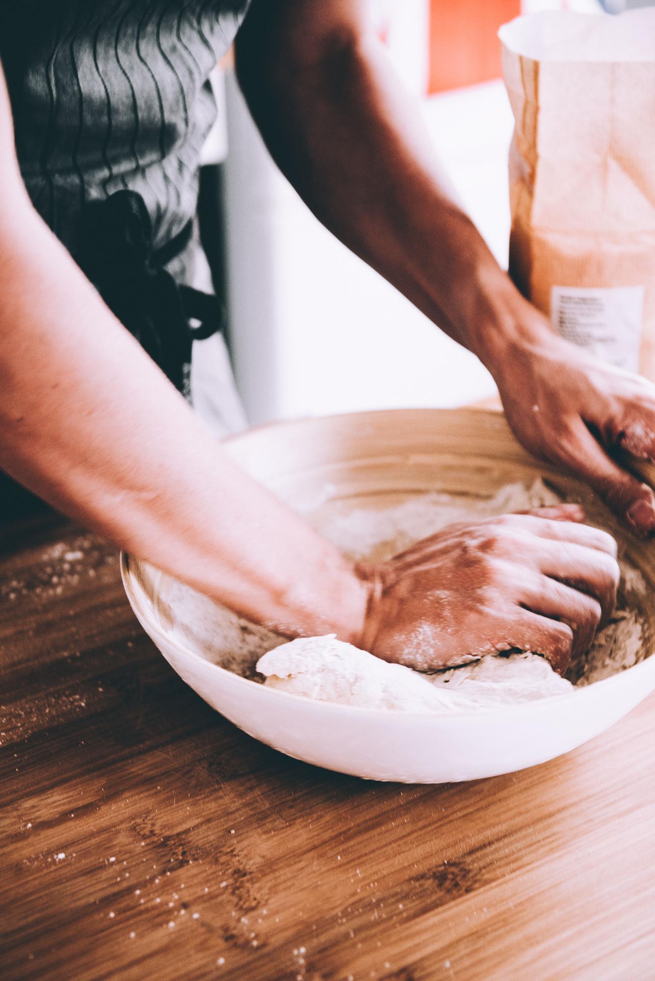 Close-up of hands kneading dough in online class